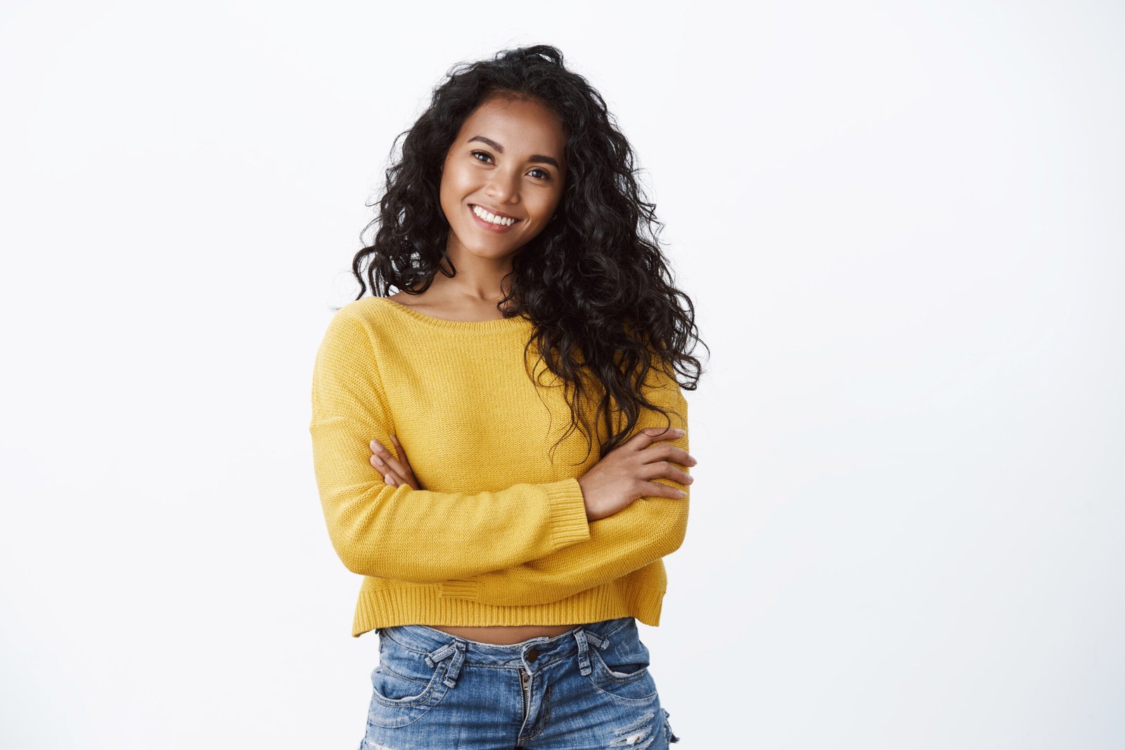 happiness, wellbeing and confidence concept. cheerful attractive african american woman curly haircut, cross arms chest in self assured powerful pose, smiling determined, wear yellow sweater